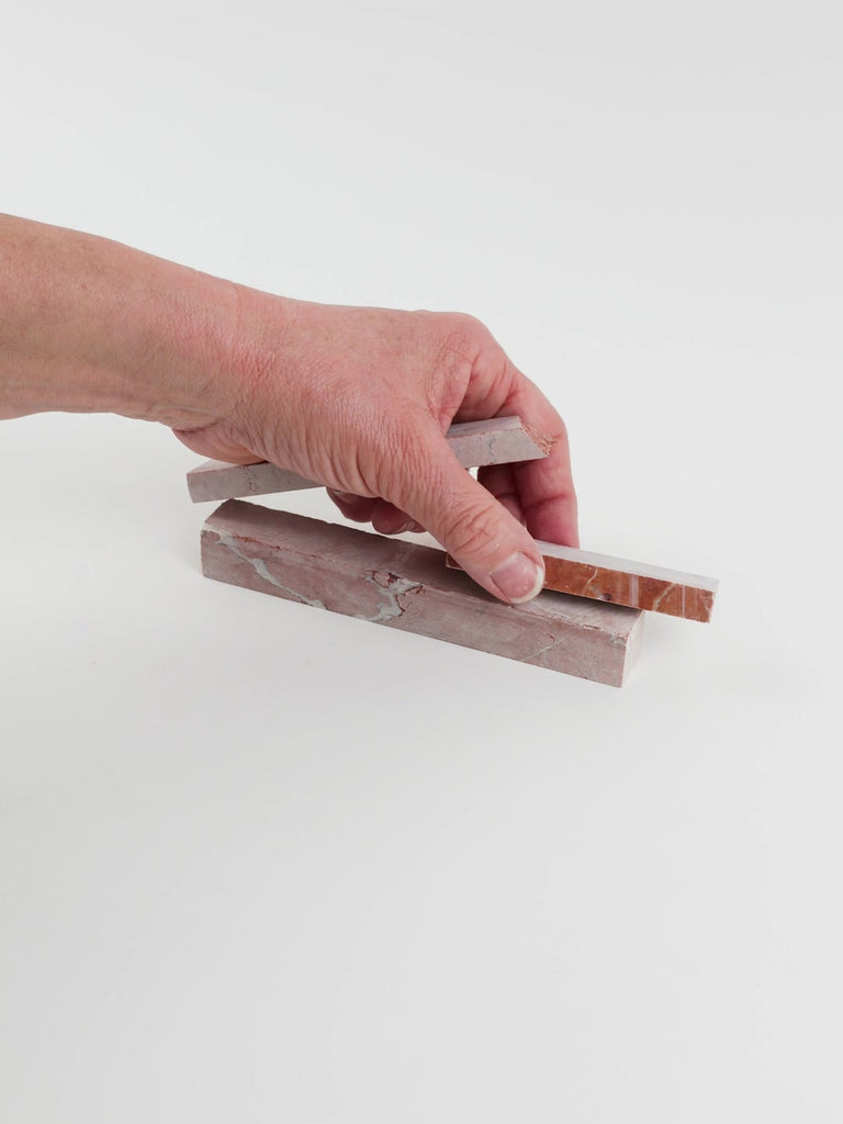 Video of Marble Bars XL Rosso Verona in opaque red natural marble, 1–20 cm long and 8 mm thick, picked up by hand and turned to show their length, colour and natural veining
