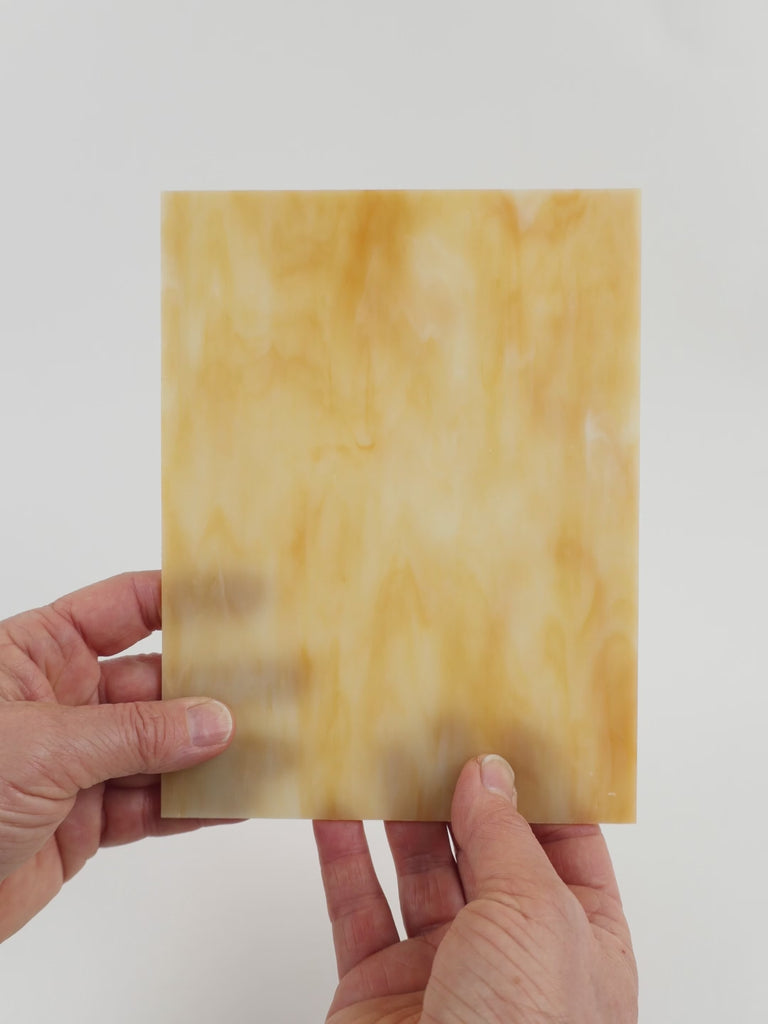 Video of the creme caramel glass plate in cmel translucent, 15x19cm, held up and tilted to show its pattern and transparency