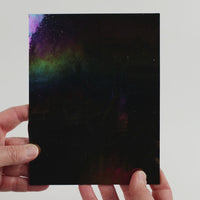 Video of the Universe glass plate in black, opaque and iridescent finish, 15x19cm, held up and tilted to show its pattern and transparency